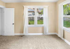 Empty room with light carpet and baseboards