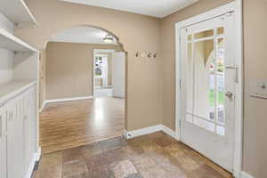 Entryway with arched walkways and stone tile floors