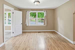 Spare room with light wood-type flooring and a textured ceiling