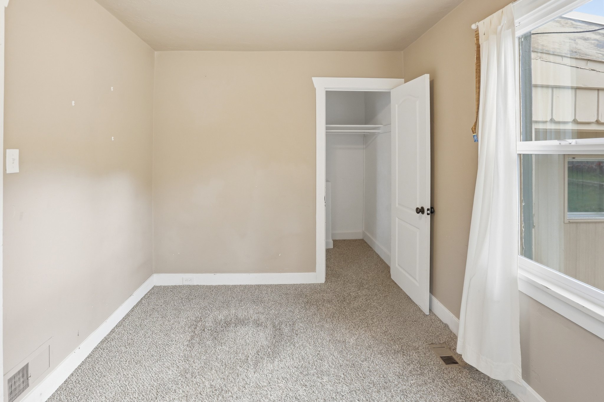 Unfurnished bedroom with light carpet and a closet