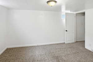 Below grade area featuring light colored carpet and baseboards