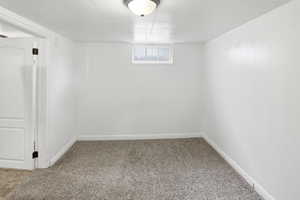 Basement with light colored carpet and baseboards