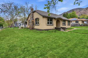 View of front facade featuring a chimney, stucco siding, and a mountain view
