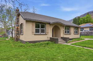 View of front of house featuring a chimney, roof with shingles, stucco siding, and a mountain view