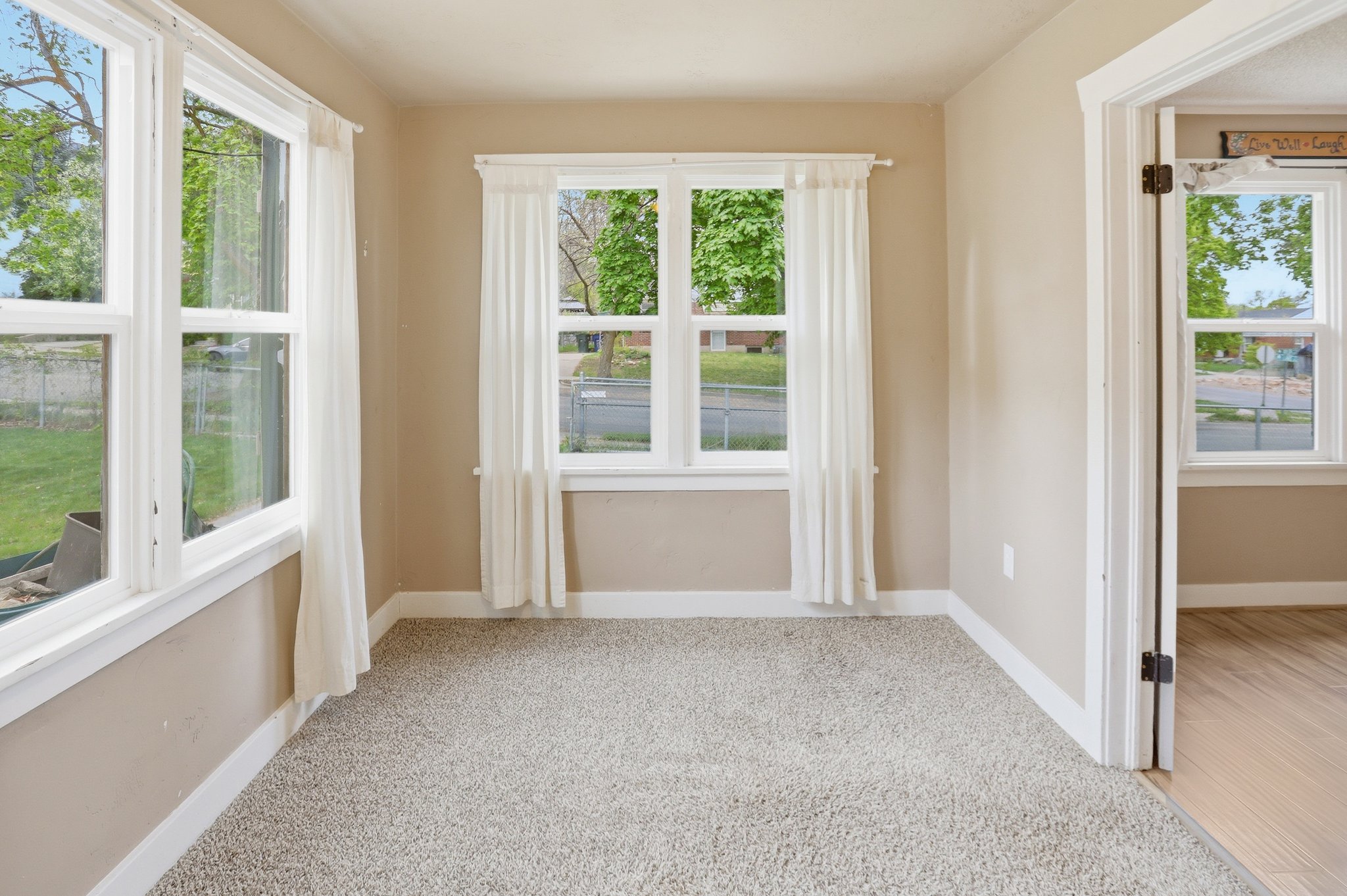 Empty room with light colored carpet and plenty of natural light