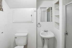 Full bathroom featuring toilet and a shower stall