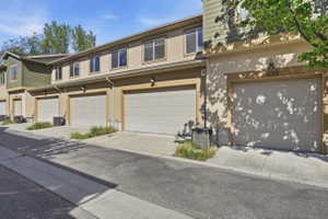 Traditional-style home featuring stucco siding, an attached garage, and driveway
