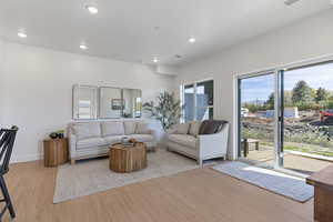 Living area with light wood finished floors, healthy amount of natural light, and recessed lighting