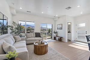 Living room featuring a mountain view, light wood-style floors, healthy amount of natural light, and recessed lighting