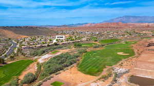 Aerial view of residential area featuring a mountain backdrop and a golf course