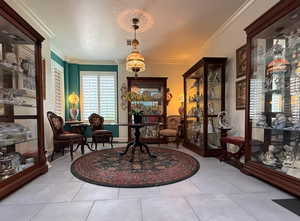 Living area featuring crown molding, a textured ceiling, and light tile patterned flooring