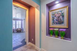 Hall featuring baseboards and light tile patterned floors