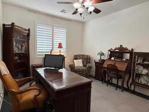Office space with a ceiling fan and light tile patterned flooring
