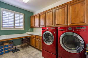 Laundry area with independent washer and dryer and cabinet space