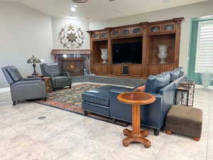 Living area featuring baseboards and a warm lit fireplace