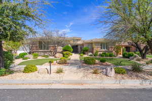 Prairie-style house featuring stone siding, stucco siding, and a front lawn
