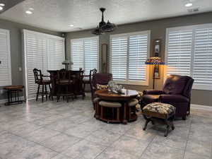 Living room with a textured ceiling, recessed lighting, and plenty of natural light