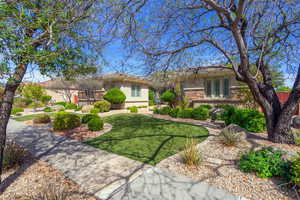 View of front facade featuring a front yard, stone siding, and stucco siding