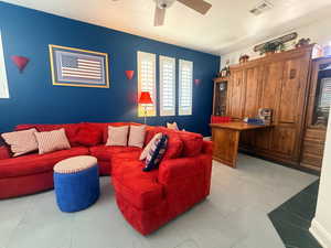 Living room with light tile patterned floors and a ceiling fan