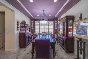 Dining room featuring a tray ceiling, recessed lighting, light tile patterned floors, and ornamental molding
