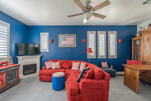 Living room with ceiling fan and light tile patterned flooring