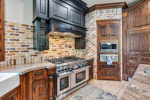 Kitchen with stainless steel appliances, a warming drawer, and light stone countertops