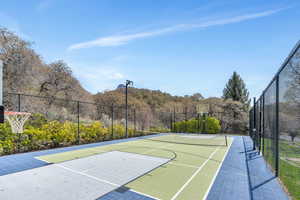 View of basketball court with community basketball court and a wooded view