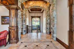 Hall featuring arched walkways, crown molding, and inlaid floor details