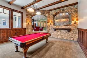Playroom with wainscoting, arched walkways, wooden walls, billiards, and beam ceiling