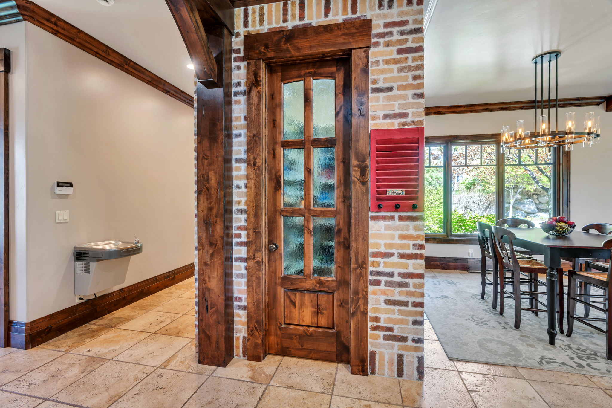 Dining space with crown molding, stone tile floors, and suspended lighting