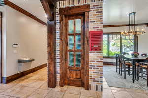 Dining space with crown molding, stone tile floors, and suspended lighting