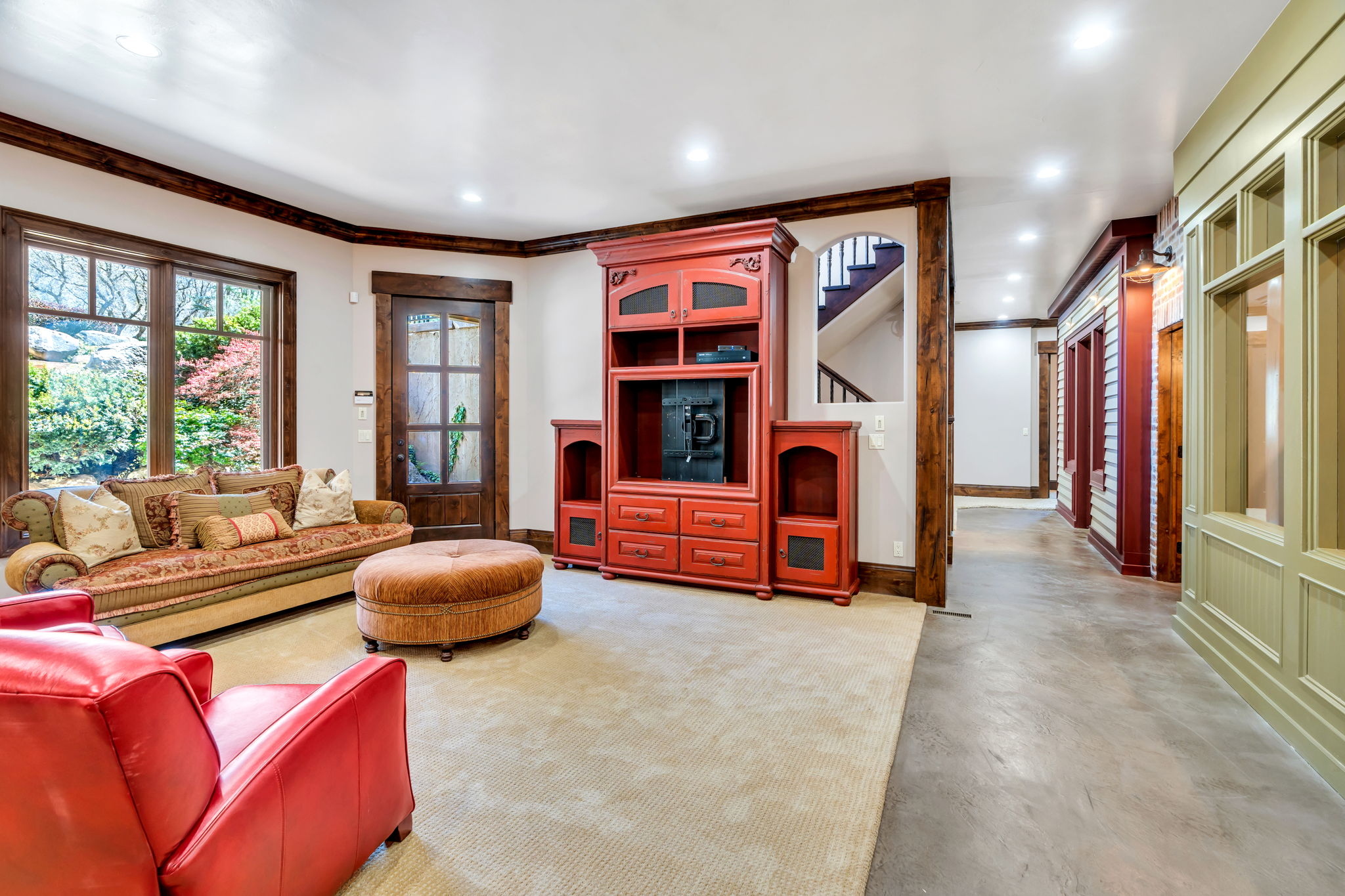 Living room with finished concrete flooring, recessed lighting, and crown molding