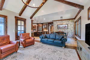 Living area featuring a chandelier, stone tile floors, and brick wall