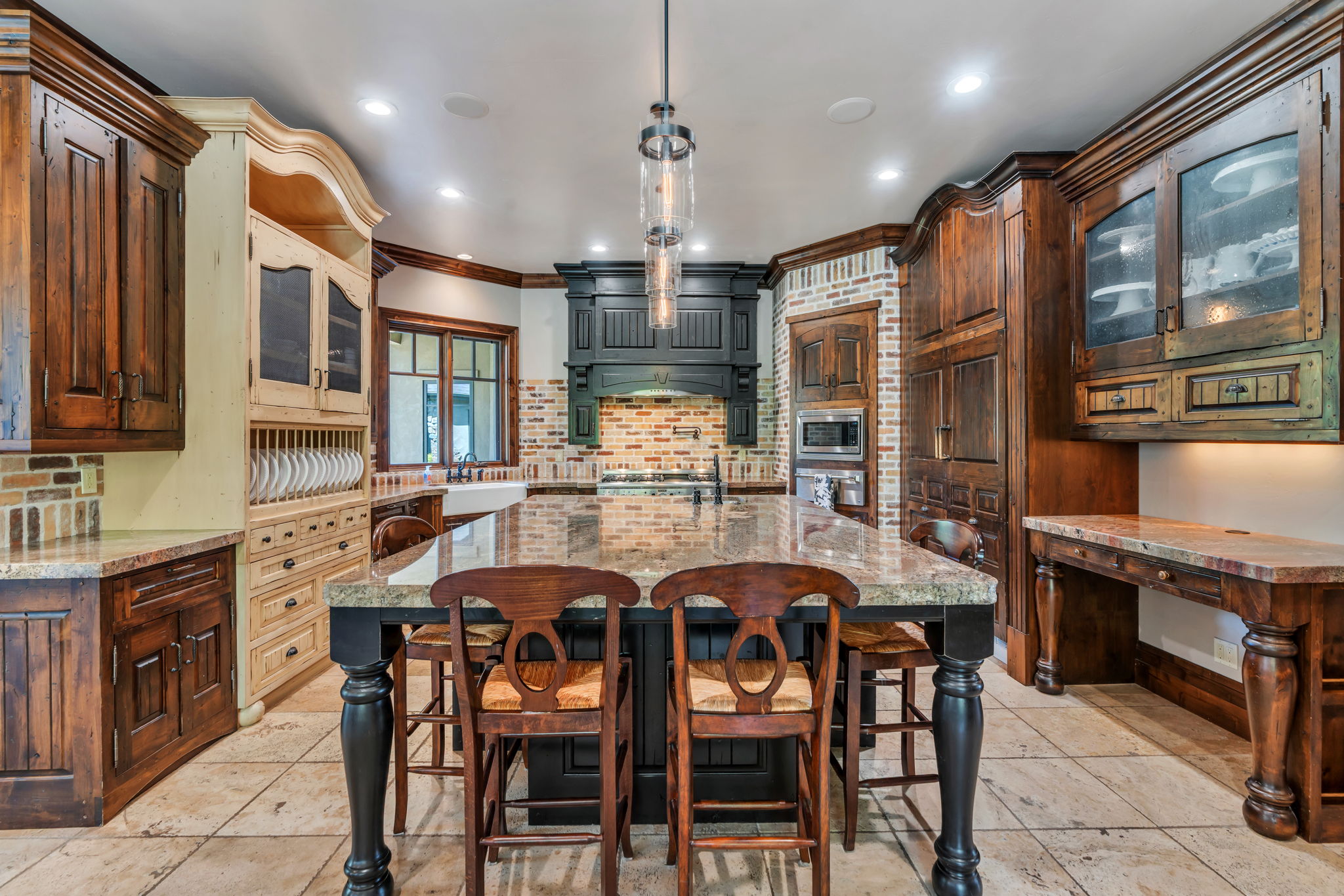 Kitchen with glass fronted cabinets, a breakfast bar, an island with sink, crown molding, and backsplash