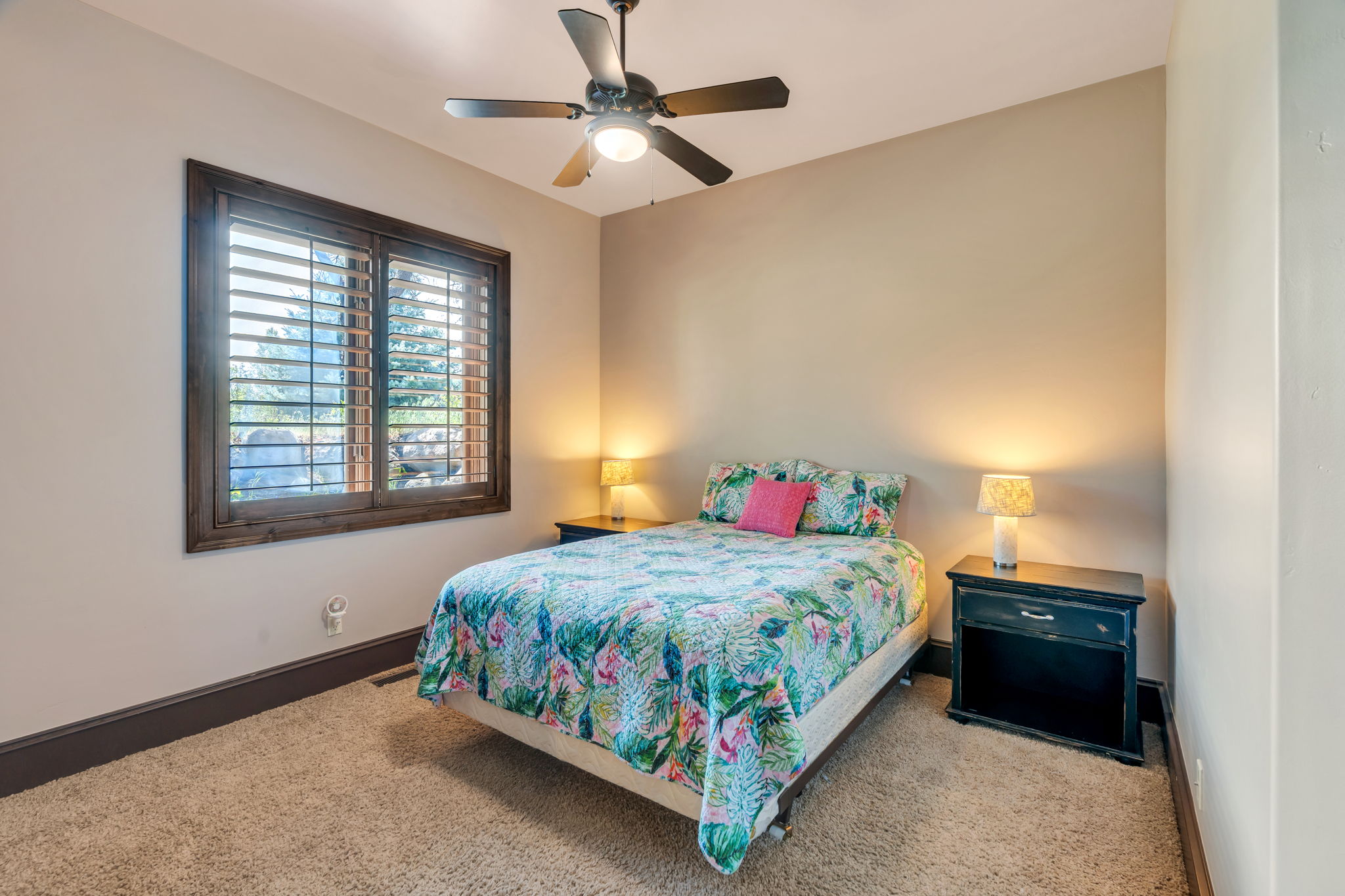Carpeted bedroom featuring baseboards and a ceiling fan