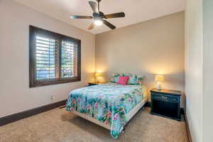 Carpeted bedroom featuring baseboards and a ceiling fan