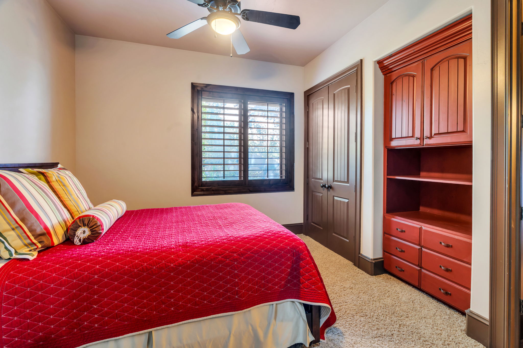 Bedroom with a closet, ceiling fan, and carpet flooring