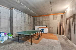 Recreation room with unfinished concrete flooring