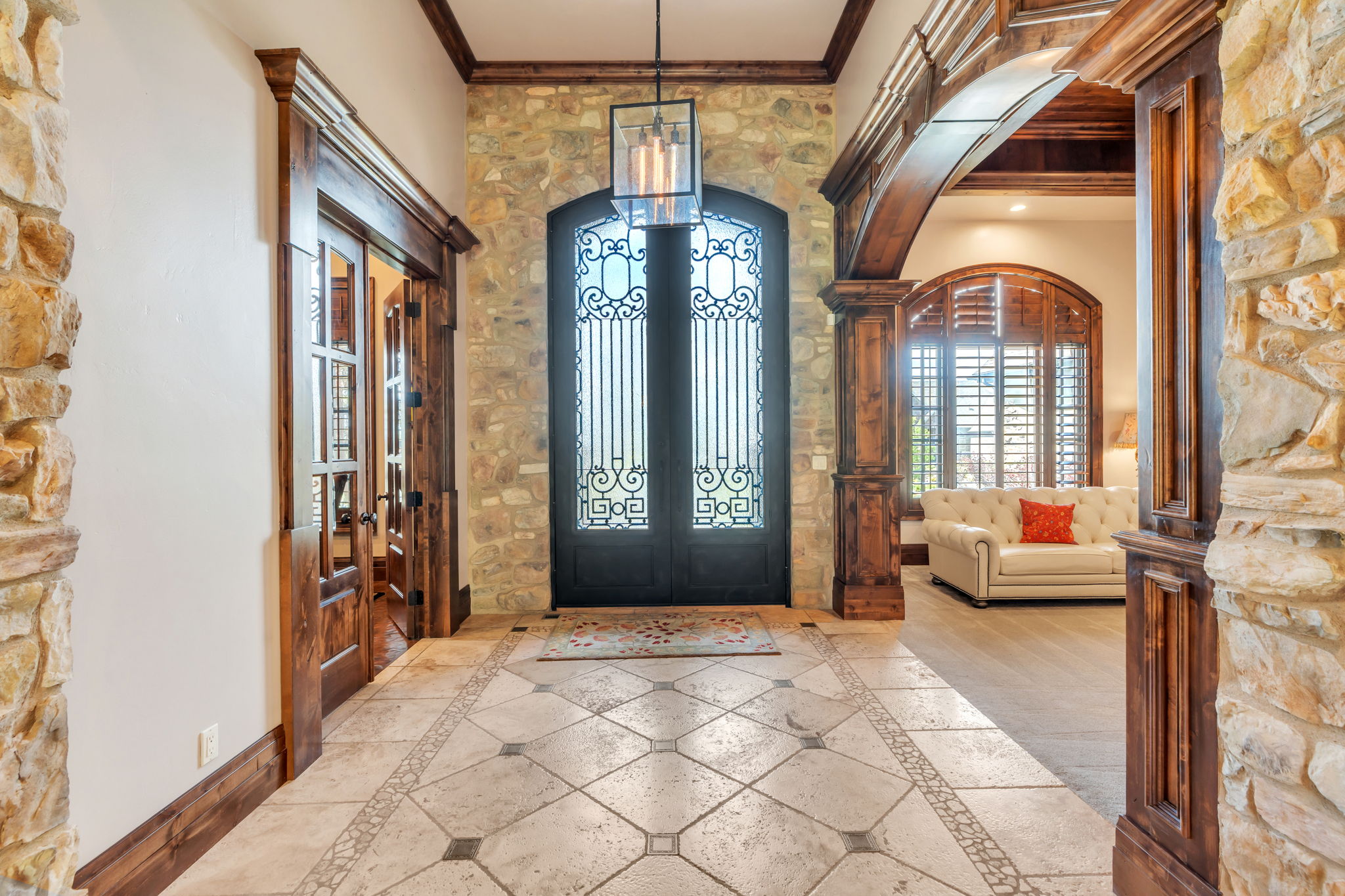 Entryway featuring french doors, arched walkways, crown molding, and inlaid floor details
