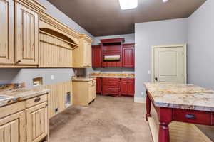 Kitchen with concrete floors, open shelves, and two tone color scheme