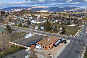 Aerial view of property and surrounding area with a mountain backdrop and nearby suburban area