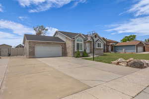 Ranch-style house featuring an attached garage, concrete driveway, a front lawn, brick siding, and a shingled roof