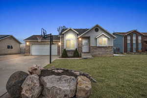Ranch-style house featuring brick siding, concrete driveway, a garage, and a front yard