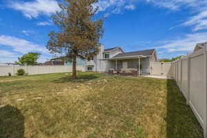Rear view of house with a gate, outdoor lounge area, a fenced backyard, and a patio area