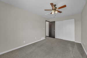 Unfurnished bedroom featuring carpet floors, a ceiling fan, and a closet