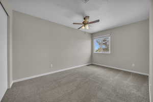 Spare room with carpet, a textured ceiling, and a ceiling fan