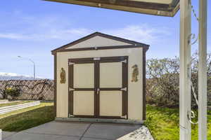 View of large Tuff Shed in the backyard with raised garden beds to the east.