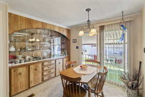 Dining room featuring sliding glass door, crown molding, and built in buffet / China cabinet with glass doors.