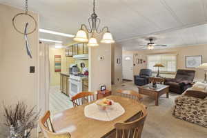 Dining room featuring a ceiling fan and light carpet