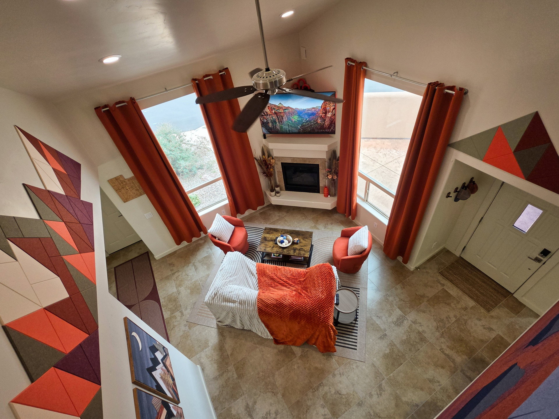 Living area featuring a ceiling fan, a glass covered fireplace, a high ceiling, and recessed lighting